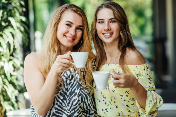 beautiful mother and daughter drinking coffee together, selective focus - Фото, зображення