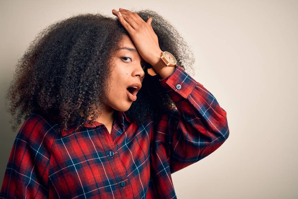 junge schöne afrikanisch-amerikanische Frau trägt lässiges Hemd über isoliertem Hintergrund überrascht mit der Hand auf dem Kopf für Fehler, erinnere dich an Fehler. Vergessenes, schlechtes Gedächtnis. - Foto, Bild