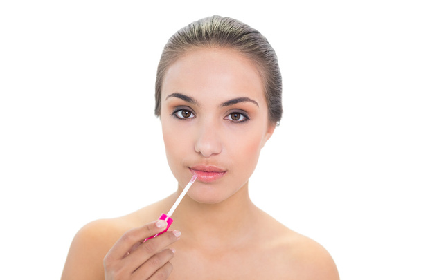 Content young woman applying lip gloss - Fotó, kép