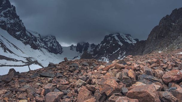 stormy sky over the snowy mountains in the highlands. Madder and Pionersky Pass in the Alatau ridge of Almaty Kazakhstan - Photo, image