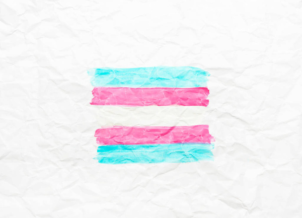 Bandera transgénero sobre papel blanco arrugado
.  - Foto, Imagen