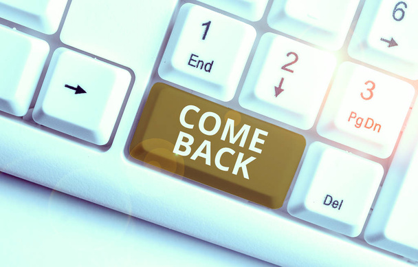 A "Gyere vissza" feliratot. Üzleti koncepció a visszatérési hely bemutatására, ahol a szerelmesek laknak Fehér PC billentyűzet jegyzet papírral a fehér háttér felett - Fotó, kép
