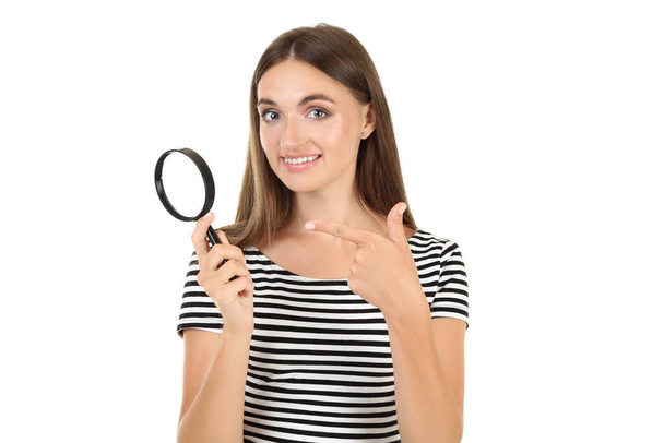 Young woman with magnifying glass on white background - Photo, image