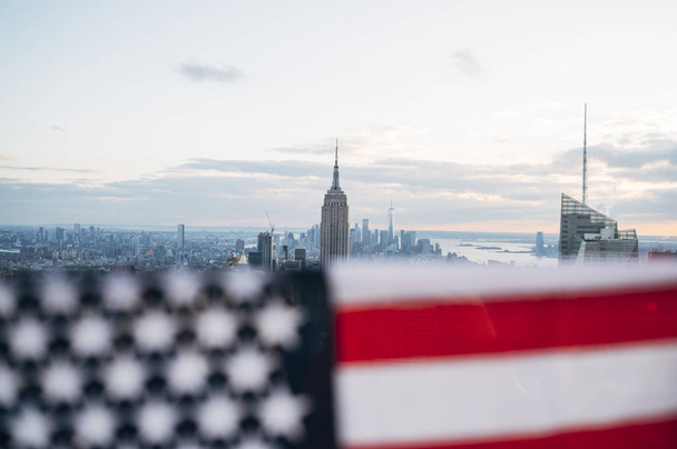 Turisti con bandiera degli Stati Uniti che guardano il paesaggio urbano di New York da un edificio
 - Foto, immagini