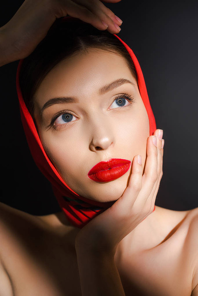 portrait of elegant young woman with red scarf, isolated on black - Фото, зображення