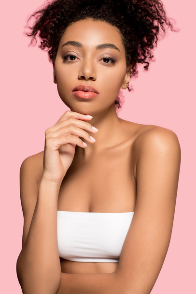 πορτρέτο του όμορφου Αφροαμερικανού κοριτσιού με καθαρό πρόσωπο, απομονωμένο σε ροζ - Φωτογραφία, εικόνα