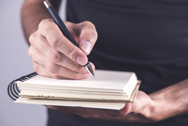 hand holding pen with notepad - Φωτογραφία, εικόνα