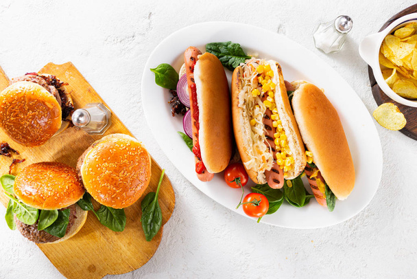 Party tavolo da pranzo con diversi hot dog fatti in casa e hamburger vista dall'alto
 - Foto, immagini