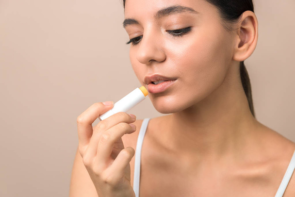 lips care and protection. woman applying balm on lips - Zdjęcie, obraz