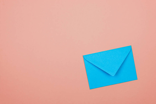 blue closed envelope in corner of a pink background - Zdjęcie, obraz