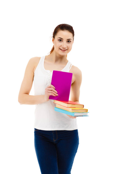 Pretty woman with natural makeup posing with colourful books isolated on white background - Photo, image