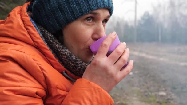 Beautiful woman drinks hot soaring tea in nature - Footage, Video