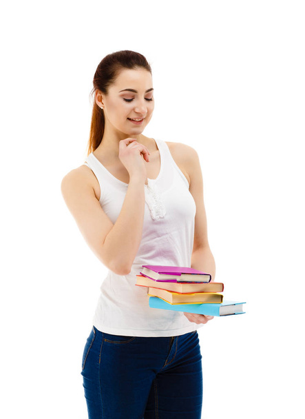 Pretty woman with natural makeup posing with colourful books isolated on white background - Foto, Imagem