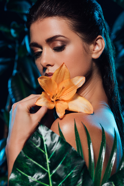 selective focus of sexy woman holding orchid near leaves  - Fotoğraf, Görsel