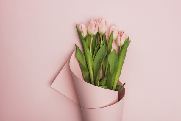 top view of tulips wrapped in paper on pink background - Photo, Image