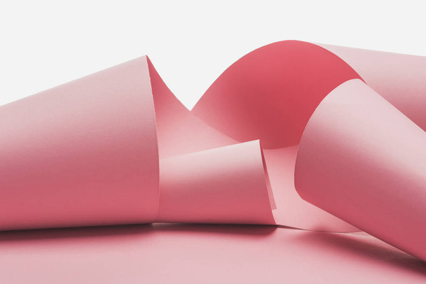 remolinos de papel rosa con sombra aislada sobre blanco
 - Foto, imagen