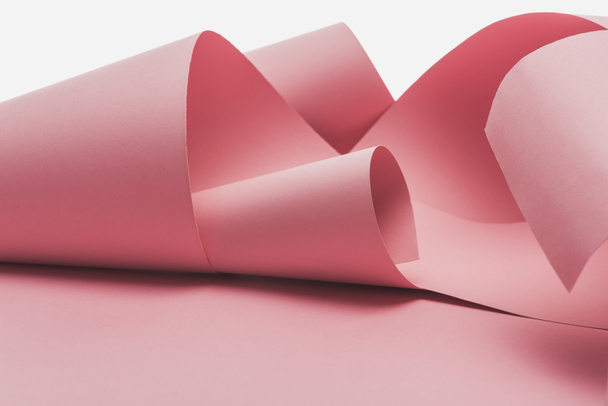 ροζ χαρτί στροβιλίζεται με σκιά απομονωμένη σε λευκό - Φωτογραφία, εικόνα
