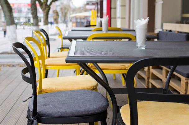 Nahaufnahme eines kleinen Straßencafés außen in gelben und grauen Farben - Foto, Bild