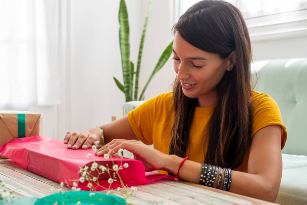Woman wrapping handmade craft gifts on the table at home - Photo, image