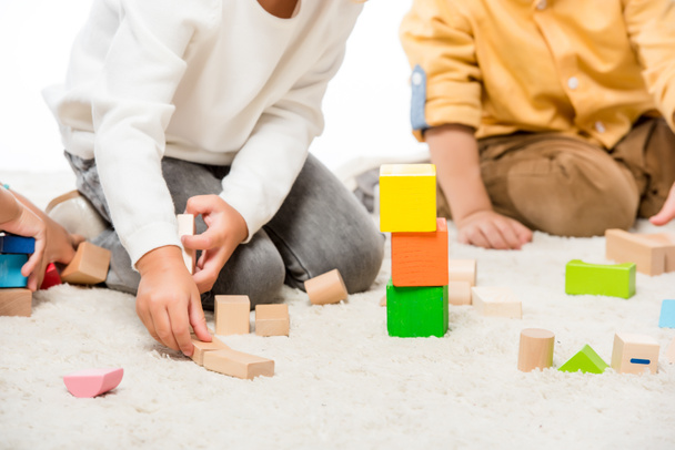 cropped view of kids playing with wooden blocks on carpet - Foto, Imagem