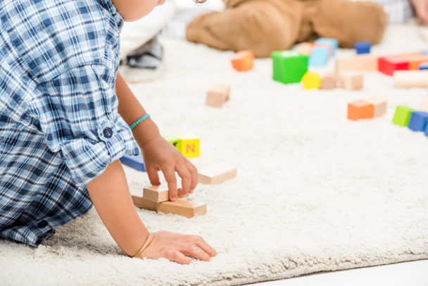 cropped view of kids playing with wooden blocks on carpet - Foto, immagini