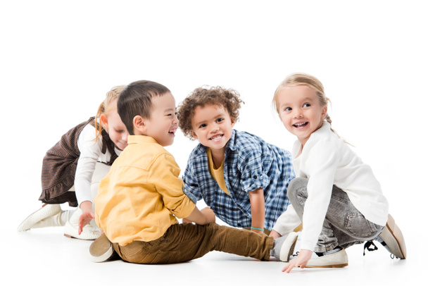 entzückend lächelnde multikulturelle Kinder, die auf Weiß spielen - Foto, Bild