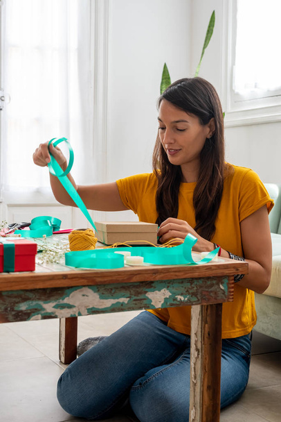Mulher embrulhando presentes artesanais na mesa em casa - Foto, Imagem
