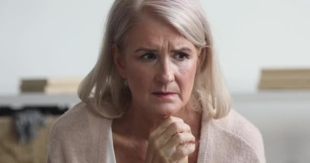 Thoughtful worried older lady concerned about health problems at home - Кадри, відео
