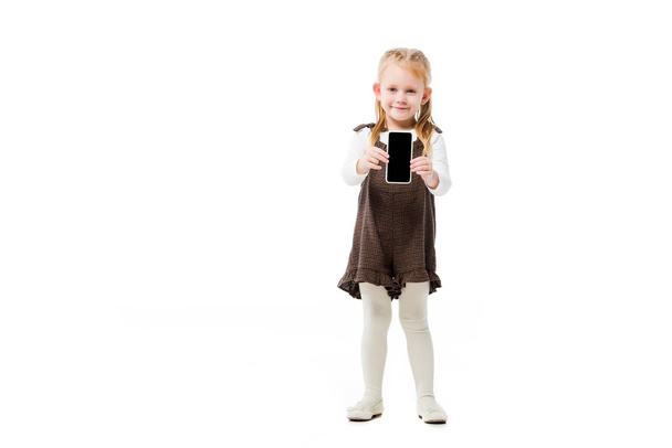 happy kid showing smartphone with blank screen, isolated on white - Фото, изображение