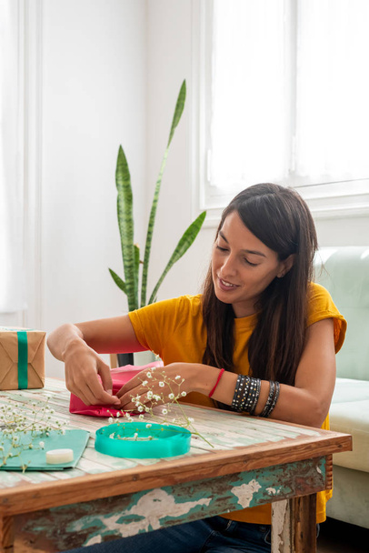 Kobieta pakowanie ręcznie robione prezenty rzemieślnicze na stole w domu - Zdjęcie, obraz