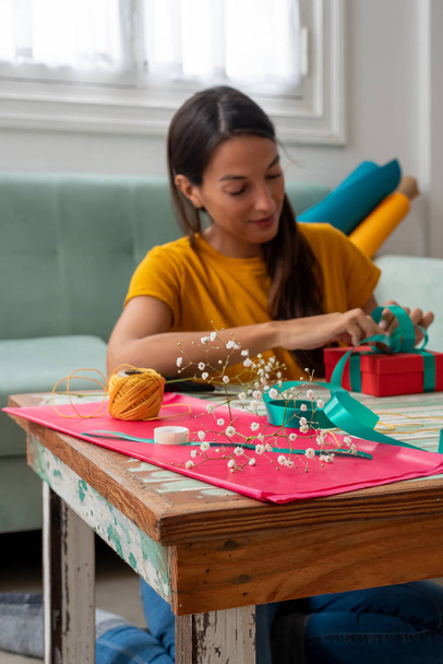 Žena balení ručně dělané řemeslné dárky na stole doma - Fotografie, Obrázek