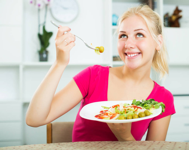 Woman eating green salad - 写真・画像