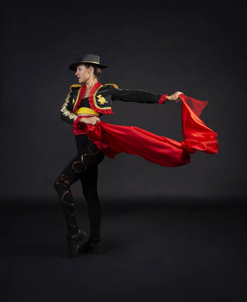Plastic girl gracefully dancing in a stage costume stylized as a bullfighter. - 写真・画像