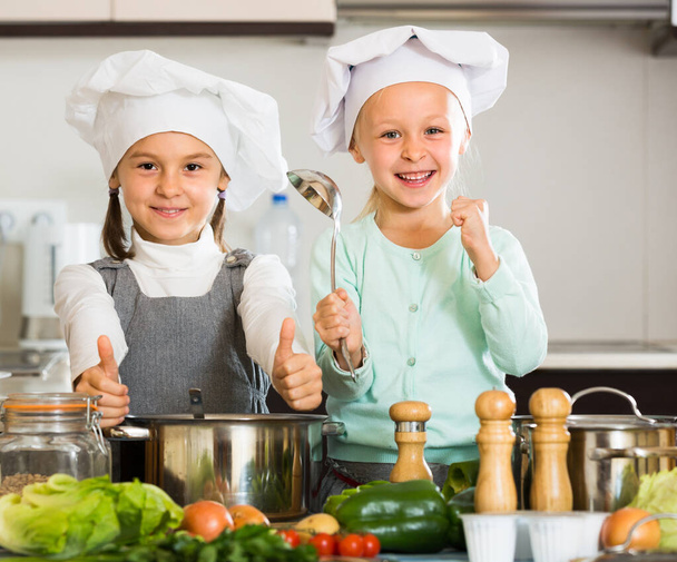 Portrait of little sisters at kitchen - Фото, изображение