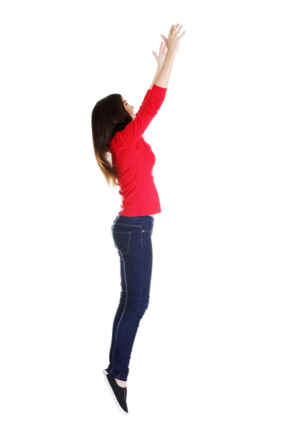 Teen girl jumping in air trying to catch something. - Foto, imagen