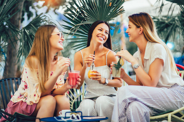Mooie meisjes drinken cocktail in cafe en hebben plezier. - Foto, afbeelding