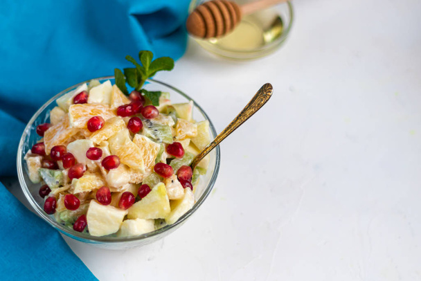 Diet fruit salad for breakfast. Kiwi orange banana and apple diced and seasoned with yogurt with honey. Healthy food, vegetarianism. - Фото, зображення