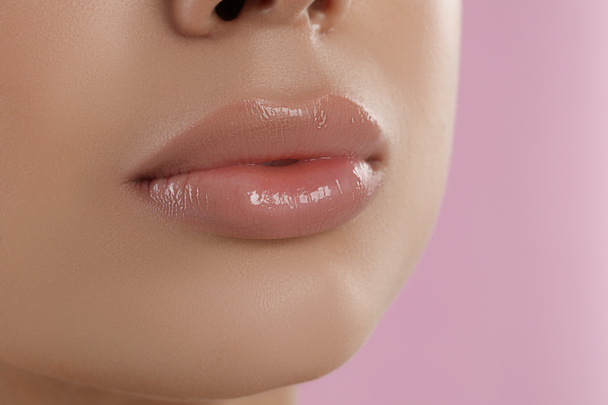 Young woman with beautiful full lips on pink background, closeup - Photo, Image