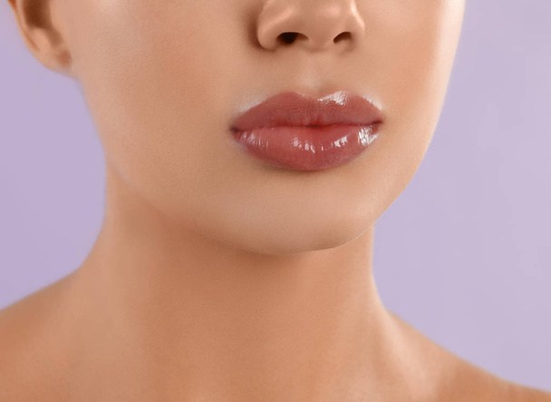 Young woman with beautiful full lips on lilac background, closeup - Foto, Bild
