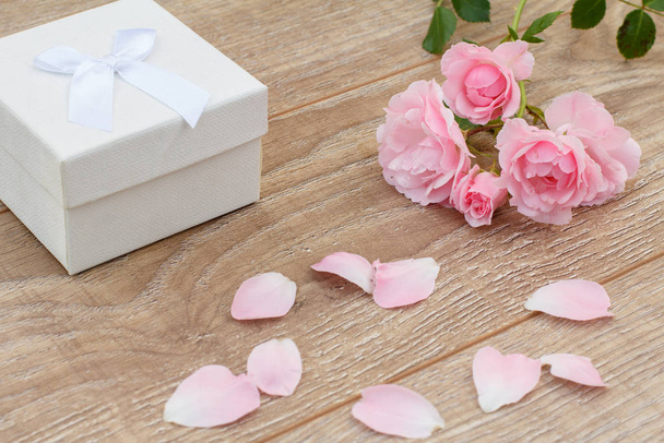 Caja de regalo con flores de color rosa sobre fondo de madera
. - Foto, imagen