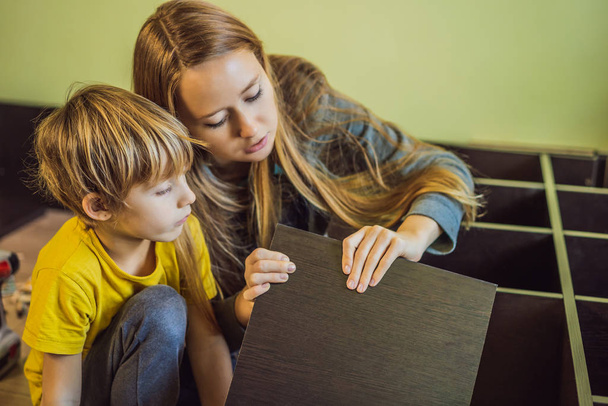 Mother and son assembling furniture. Boy helping his mom at home. Happy Family concept - Φωτογραφία, εικόνα