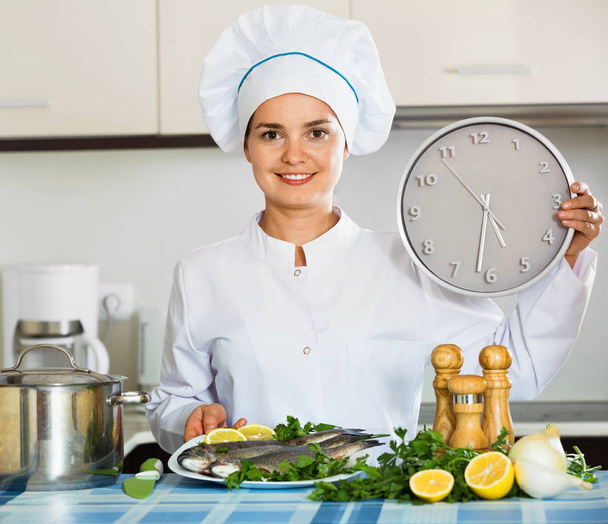 Portrait of chef holding big clock - Foto, Bild