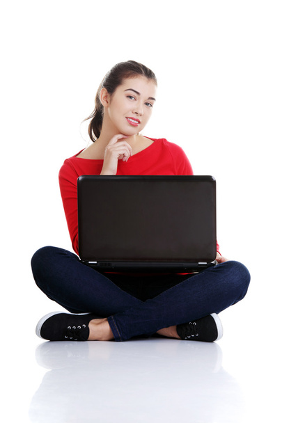 Happy young woman using her laptop - Фото, изображение