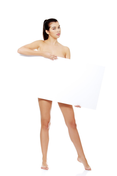 Sexy naked brunette holding empty board - Foto, afbeelding