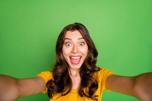 Self-portrait of her she nice attractive lovely cheerful cheery crazy ecstatic wavy-haired girl having fun free time isolated over bright vivid shine vibrant green color background - Foto, imagen