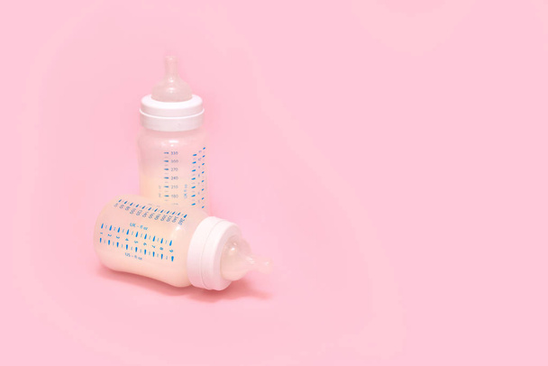 Bottle of milk for a newborn on a pink background. - Foto, Imagen