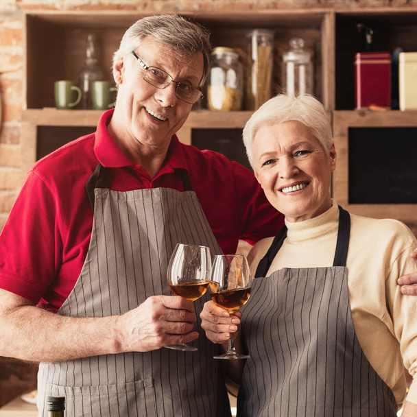 Щасливий старший коханий чоловік і жінка насолоджуються вином на кухні
 - Фото, зображення