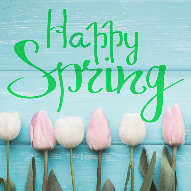 fröhlicher Frühlingstext mit Blumen auf weißgetünchtem Holz - Foto, Bild