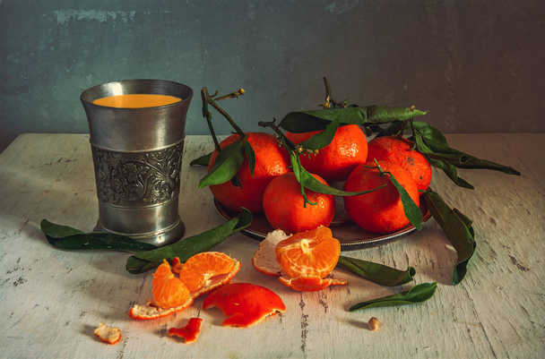 Still life with tangerines and fresh juice. Ripe citrus fruits. Healthy and tasty food, drink or dessert. - Photo, Image