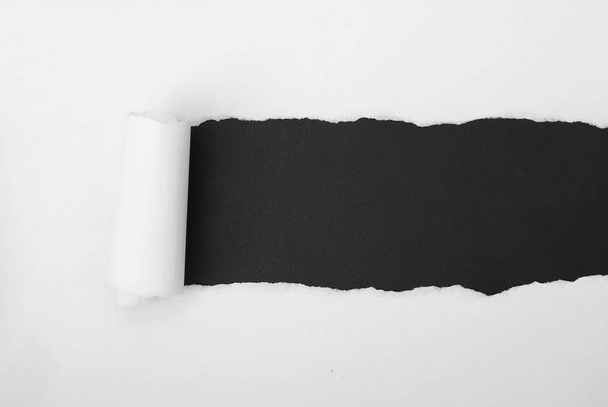 torn white paper frame on black backdrop - Zdjęcie, obraz